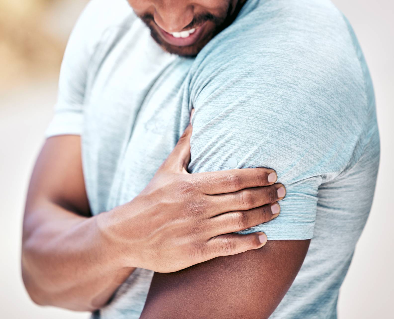 closeup-fit-mixed-race-man-holding-his-shoulder-in