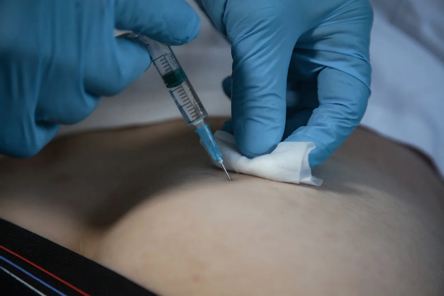 injection with gloved hands and white